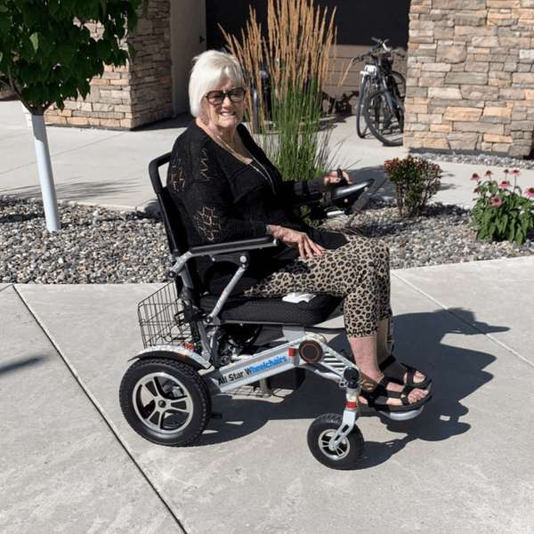 Senior woman sitting comfortably and confidently in an All Star power wheelchair outside her home